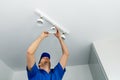 Electrician installing led light bulbs in ceiling lamp