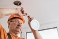 The electrician is installing an LED spotlight Royalty Free Stock Photo