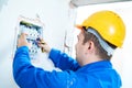 Electrician installing switching electric actuator in fuse box Royalty Free Stock Photo