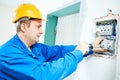 Electrician installing switching electric actuator in fuse box Royalty Free Stock Photo