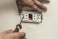 An electrician installs a new replacement 2 gang outlet to an outdoor wall. A handyman doing electrical home repair