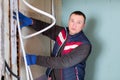 Electrician lying down cable duct during repair works