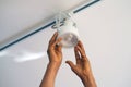 Electrician man worker installing a ceiling LED spotlight