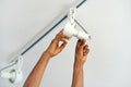 Electrician man worker installing a ceiling LED spotlight Royalty Free Stock Photo