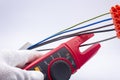The electrician measures the current in the phase wire with a meter Royalty Free Stock Photo