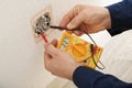 Electrician measuring voltage of socket