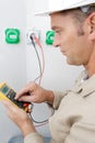 Electrician measuring voltage socket in new building Royalty Free Stock Photo