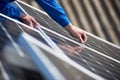 Electrician mounting solar panel on roof of modern house