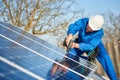 Electrician mounting solar panel on roof of modern house Royalty Free Stock Photo