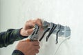 Electrician mounts a new socket on a white wall