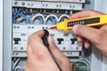 Electrician with multimeter probe at an electrical switchgear ca Royalty Free Stock Photo