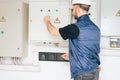 Electrician opens a large electric box. Engineer checks the electrical supply system. A technician turns off electrical machines