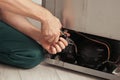 Electrician with pliers fixing refrigerator, closeup Royalty Free Stock Photo