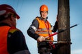 Electrician on a pole against the blue sky