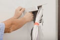 Electrician preparing place for installing switchboard indoors, closeup