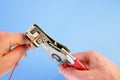 An electrician removes insulation from a copper wire. Working with the tool. Stripper work close-up. Device for removing Royalty Free Stock Photo