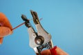 An electrician removes insulation from a copper wire. Working with the tool. Stripper work close-up. Device for removing