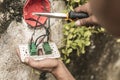 An electrician removes an old and defective electrical outlet from the concrete wall. Using pliers to cut the wires Royalty Free Stock Photo