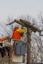 Electrician repair system of electric wire on wooden pylon after snowfall wet snow to electric wires