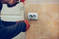 Electrician repair a wall socket. Closeup of man repairing an electrical outlet. Hazardous concept, high voltage, risk Royalty Free Stock Photo