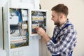 Electrician repairing fuse box with screwdriver Royalty Free Stock Photo