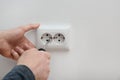 Electrician repairing wall sockets on white