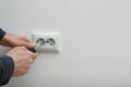 Electrician repairing wall sockets on white background, closeup.