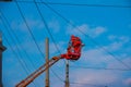 Electrician repairing wire of the power line with bucket hydraulic lifting platform on blue sky Royalty Free Stock Photo