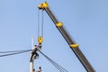 Electrician repairing wire of the power line on electric power pole with crane.