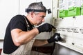 Electrician repairs and measures fuse box or switch box Royalty Free Stock Photo