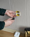 Electrician`s hands installing built-in socket in wall
