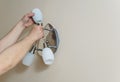 Electrician`s hands are instilling a wall lamp