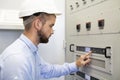Electrician service man configurates of electrical controller. Maintenance works. Engineering services on industrial complex