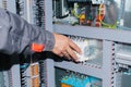 Electrician specialist checking low-voltage cabinet equipment