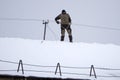 Electrician standing on top roof and looking away while thinking. Rear view of construction worker holding safety helmet looking a