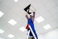 Electrician On Stepladder Installs Lighting To The Ceiling Royalty Free Stock Photo