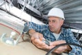 Electrician on stepladder installs lighting to ceiling in office Royalty Free Stock Photo