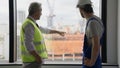 Electrician technician and contractor foreman talking together on building site