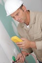 electrician technician fixes electric cable to socket Royalty Free Stock Photo