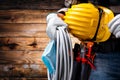 Electrician technician with tool belt and surgical mask on rustic wooden background. Electricity. Covid-19 prevention Royalty Free Stock Photo