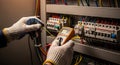 Electrician Testing Voltage in Circuit Breaker Panel with Multimeter Royalty Free Stock Photo