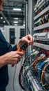 electrician testing wires in electrical control panel inside industrial facility Royalty Free Stock Photo