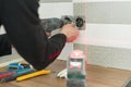 Electrician using infrared laser level to install electrical outlets. Renovation and construction in kitchen