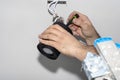 An electrician, using a screwdriver, assembles modern LED lighting in the shape of a tube, painted with matt black paint, with a c Royalty Free Stock Photo