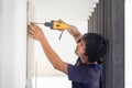 Electrician using a screwdriver, Technician installing air conditioning in a client house, Repairman fixing air conditioner unit, Royalty Free Stock Photo