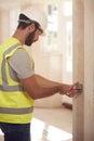 Electrician Wearing Hard Hat Fitting Light Switch At New Build Property Royalty Free Stock Photo