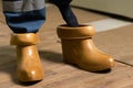 Electrician wears rubber boots. Electrical technician is putting on special protective shoes. High voltage power station