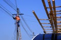 Electrician on wooden ladder are working to install electrical system on electric power pole against blue sky Royalty Free Stock Photo