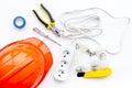 Electrician work concept. Hard hat, tools, cabel, socket outlet on white background top view Royalty Free Stock Photo
