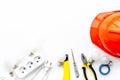 Electrician work concept. Hard hat, tools, socket outlet on white background top view Royalty Free Stock Photo